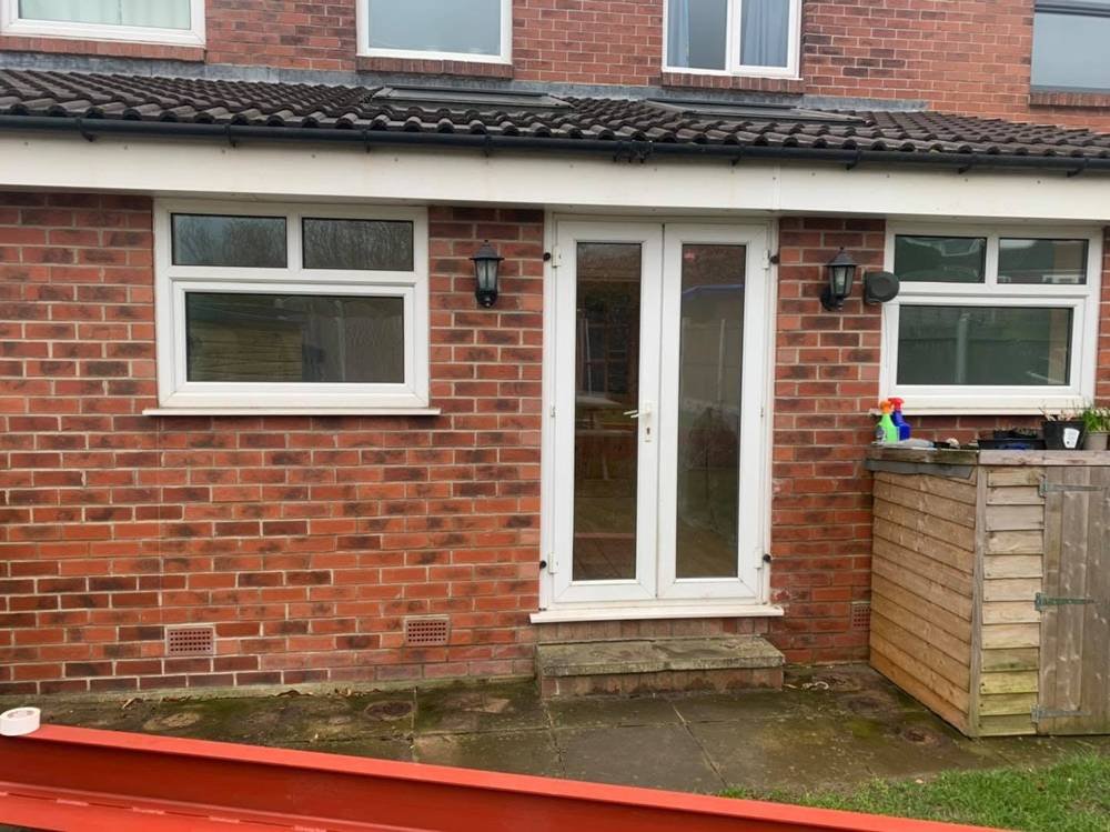 Before: white French doors on brick extension