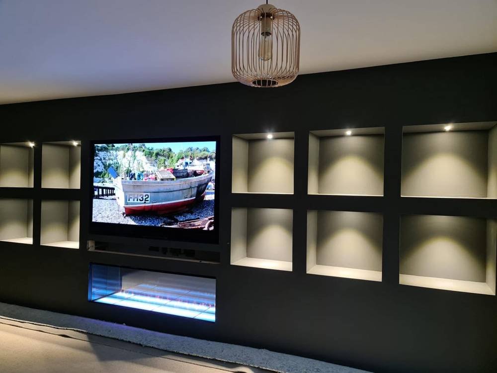 After: media wall with lit alcoves and fireplace
