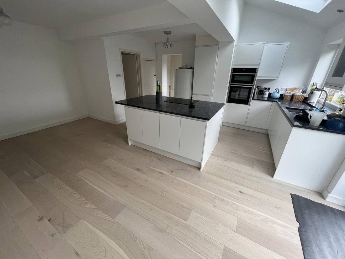 Open-plan kitchen with island and engineered wood flooring