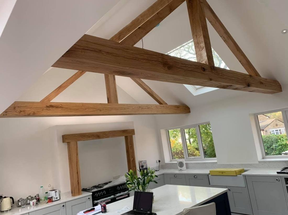 Vaulted kitchen with exposed oak trusses and oak mantel